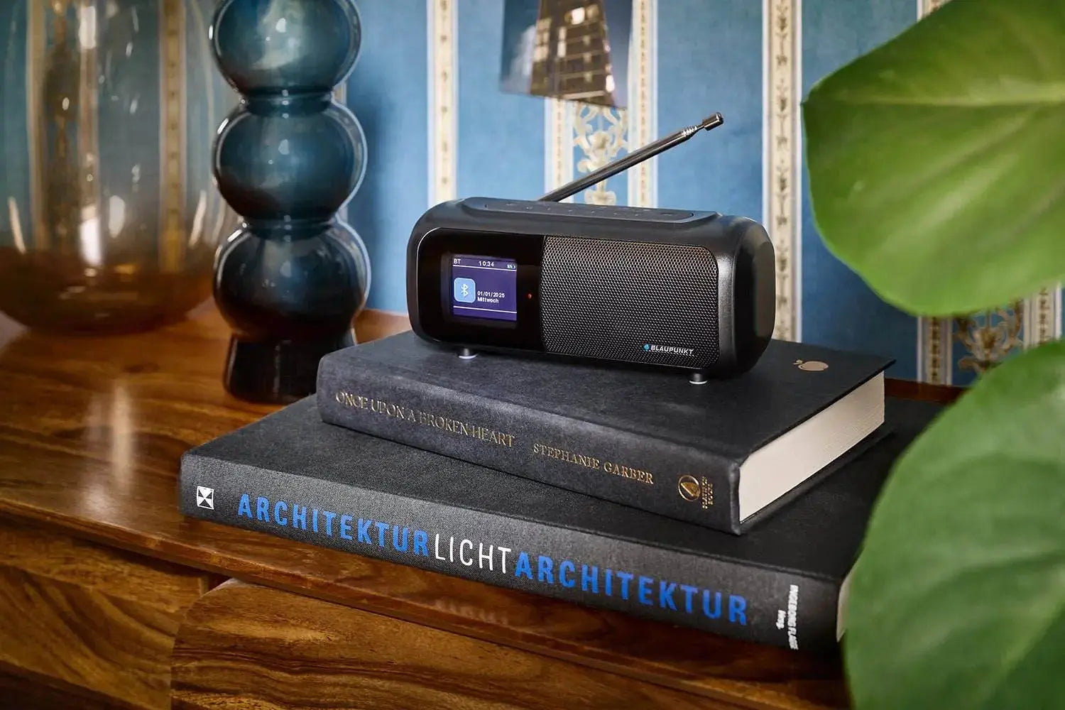 Blaupunkt BTR 100 DAB Radio Bluetooth with color display and waterproof design on books.