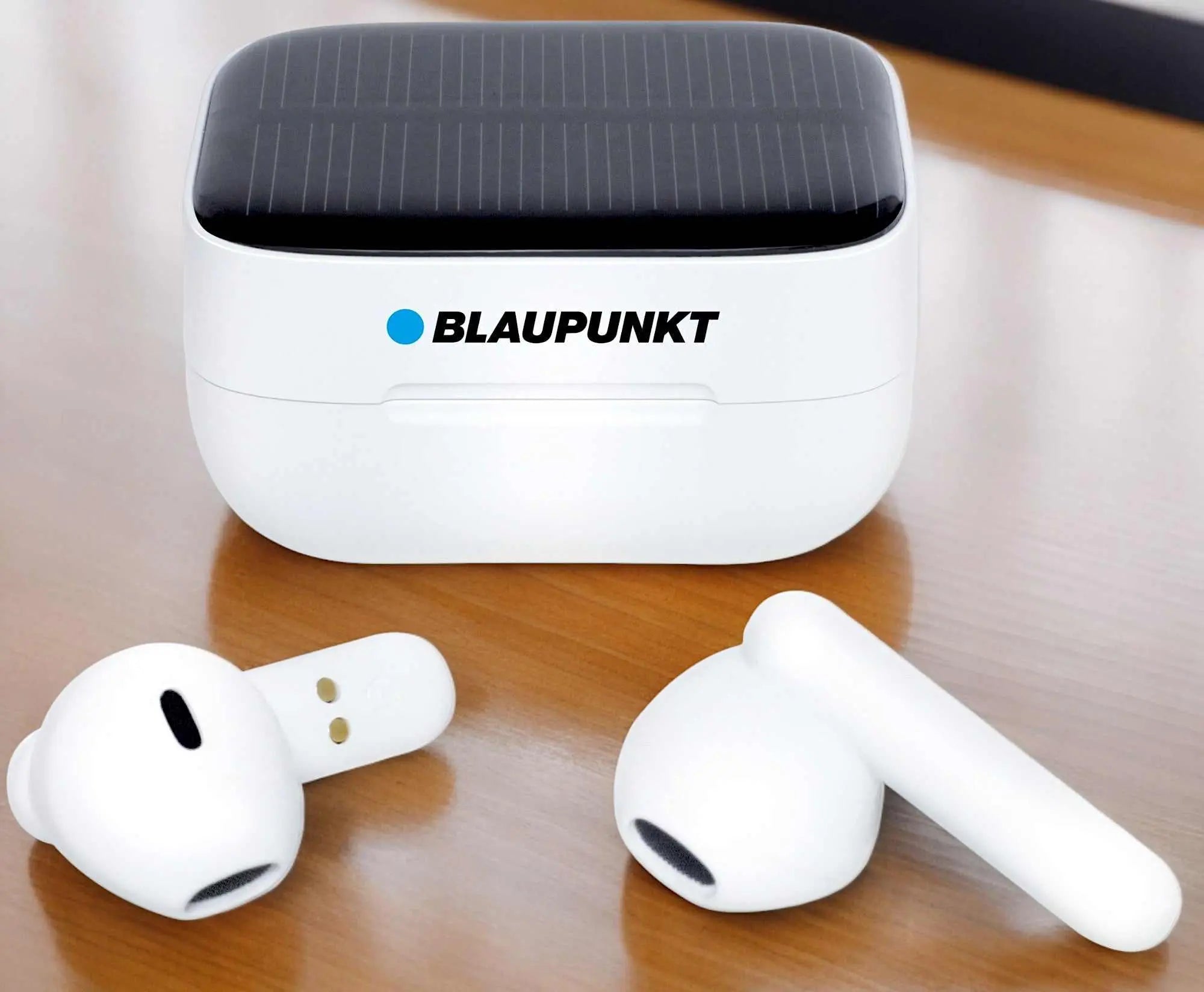 Weiße TWS 40-Kopfhörer mit geschlossenem Solar-Ladecase auf Holzuntergrund.